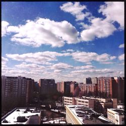 View of cityscape against cloudy sky