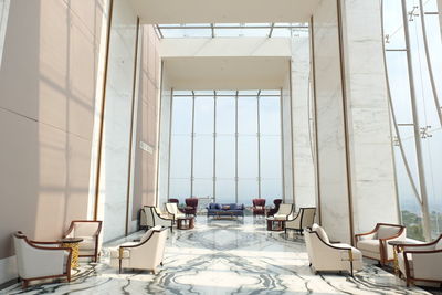Empty chairs and tables in glass window