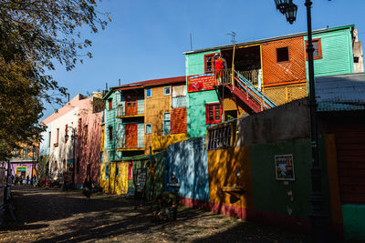 Houses by street against sky in city