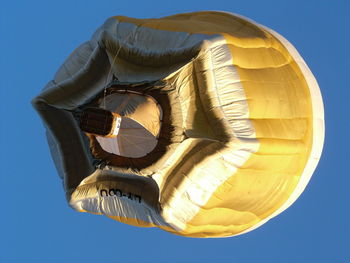 Low angle view of yellow flag against blue sky