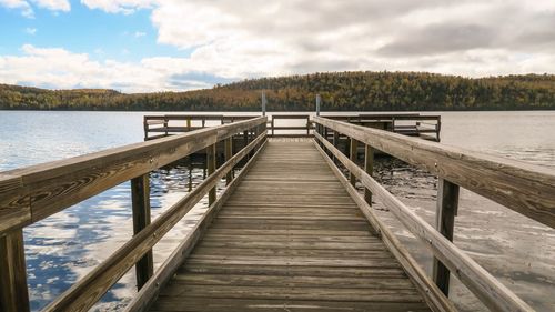 Pier over lake against sky