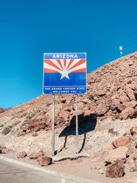 Information sign on rock against clear blue sky