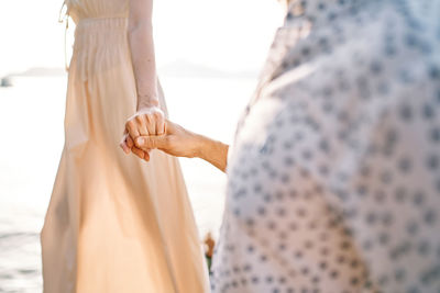 Midsection of couple holding hands