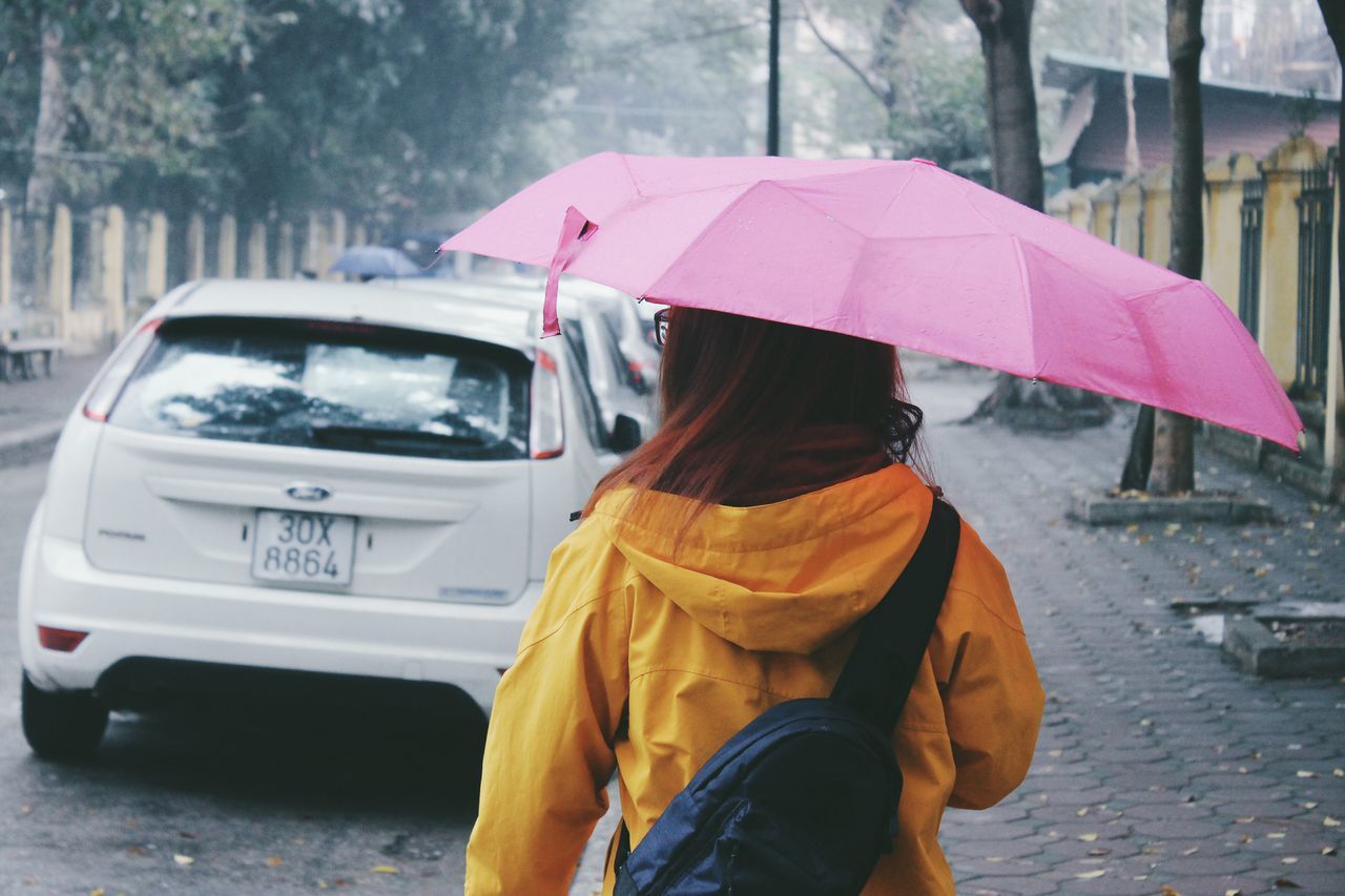 rain, weather, transportation, waiting, wet, outdoors, day, standing, pink color, rainy season, real people, one person, women, adults only, adult, people