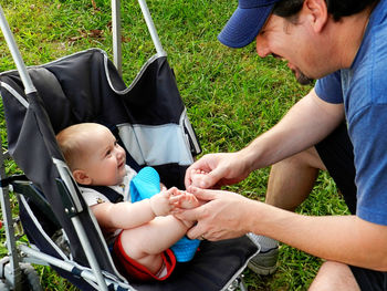 High angle view of man playing with baby in carriage