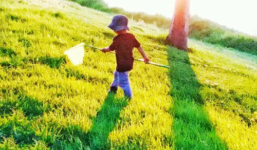Full length of boy walking on grassy field