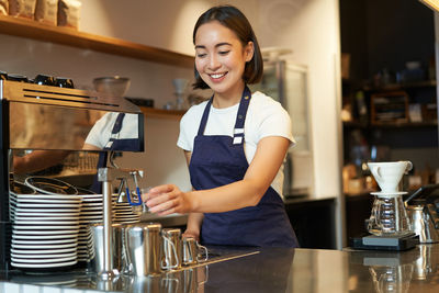 Portrait of young woman preparing food at home