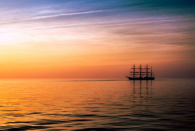 Silhouette ship sailing on sea against sky during sunset