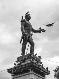 Low angle view of statue against cloudy sky