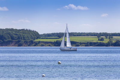 Sailboat sailing on sea against sky