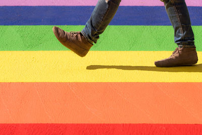 Low section of man walking on colorful street