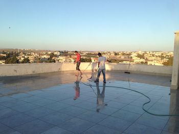 People standing on floor against buildings in city