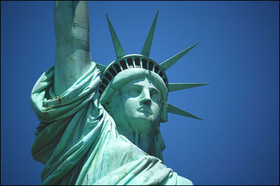 Low angle view of statue against blue sky