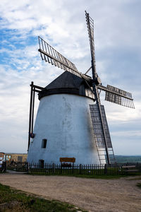 Traditional windmill on field against sky