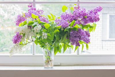 Close-up of flower vase on window sill