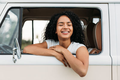 Portrait of a smiling young woman sitting in car