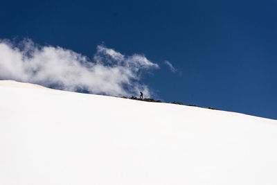 Scenic view of snowcapped mountains against blue sky