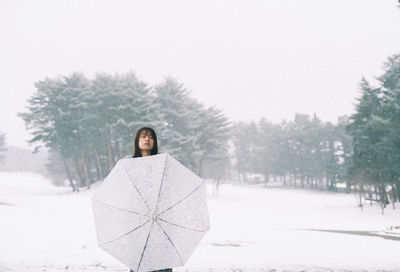 Portrait of woman standing on snow covered field