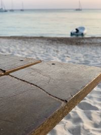 Close-up of wooden post on beach against sky