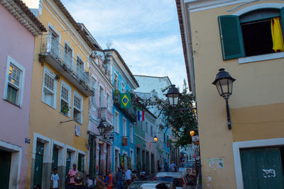 Low angle view of buildings by street against sky