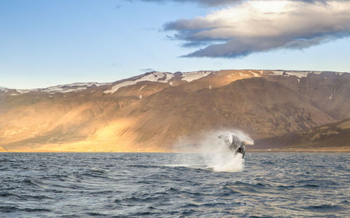 Scenic view of sea against mountain range