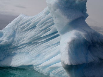 Frozen sea against sky during winter