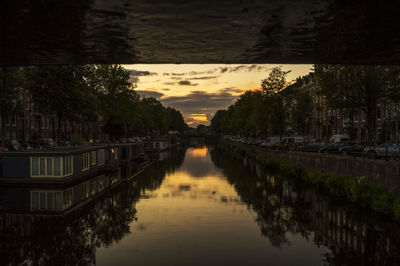 Scenic view of wet city against sky at sunset