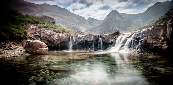 Scenic view of waterfall against sky