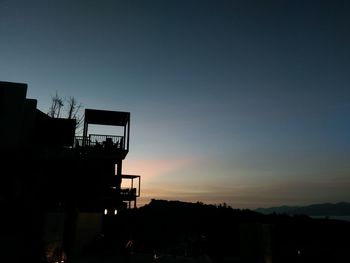 Silhouette buildings against sky during sunset