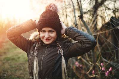 Portrait of smiling young woman wearing warm clothing during winter