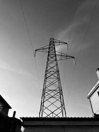 Low angle view of silhouette electricity pylon against sky