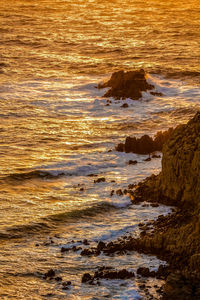 View of rocks at beach during sunset