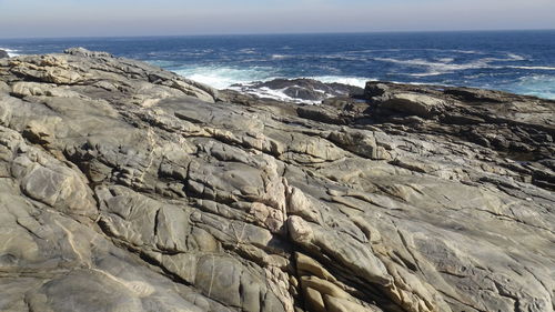 Scenic view of rocks on beach against sky