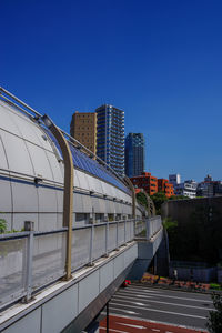 Buildings in city against clear blue sky