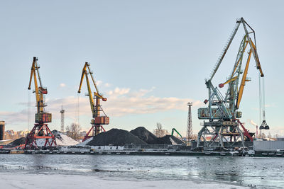 Massive harbor cranes in seaport. heavy load dockside cranes in port, cargo container yard