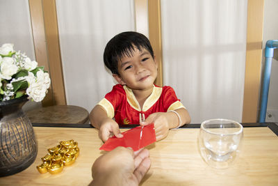 Portrait of boy sitting on table