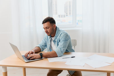 Young businesswoman using laptop at office