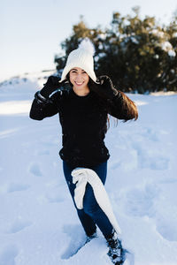 Full length of woman wearing hat on field during winter