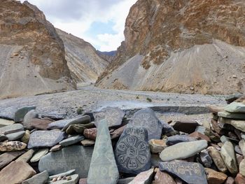 Rocks on mountain against cloudy sky