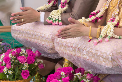Midsection of couple with hands clasped during wedding ceremony