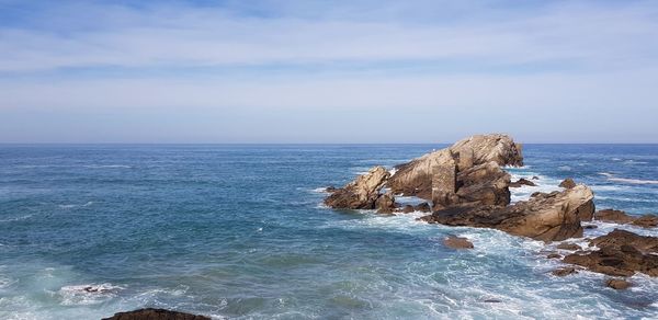 Rock formation in sea against sky