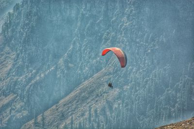 People paragliding against mountain