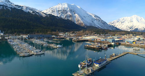 Sailboats moored at harbor against sky during winter