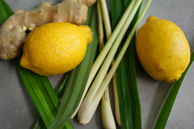 High angle view of lemon with ginger and vegetables on table