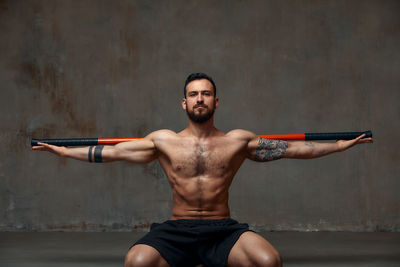 Man practicing with combat stick in gym