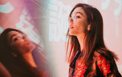 Close-up of young woman standing outdoors at night