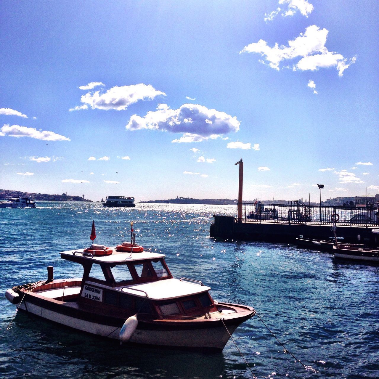 water, nautical vessel, sea, transportation, boat, mode of transport, moored, sky, waterfront, pier, harbor, built structure, rippled, blue, nature, tranquility, tranquil scene, jetty, building exterior, outdoors