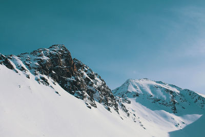 Low angle view of snowcapped mountains against sky