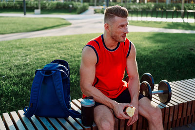 Portrait of young man sitting on street