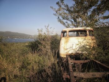 Abandoned truck on field against sky